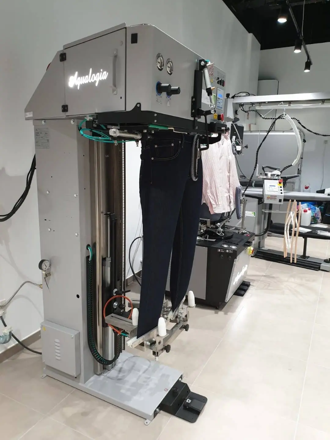 Équipement professionnel de mise en forme des vêtements dans un atelier Aqualogia.